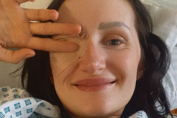Gorgina covers her eye with her hand, the eye has a plaster over it