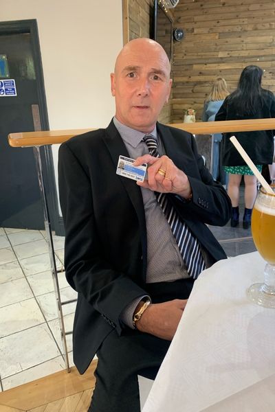 One of the brain injury survivors who Samantha supports proudly holds his ID Card