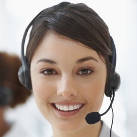 Stock image of a lady smiling at the camera wearing a telephone headset