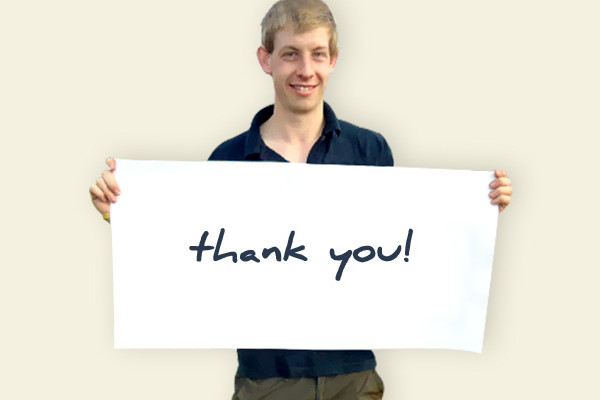 Brain injury survivor Simon Hales holds a sign saying thank you