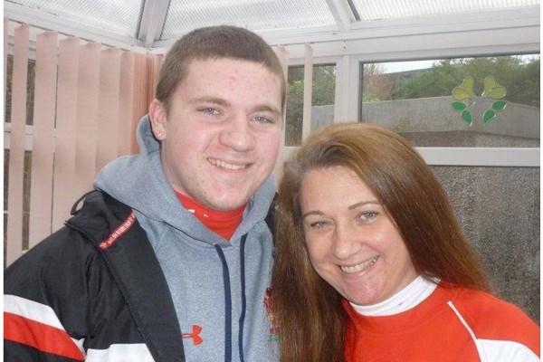 Nick O'Leary (right) with his mother, Linda. A conservatory is in the background, and they are standing close to each other smiling at the camera.