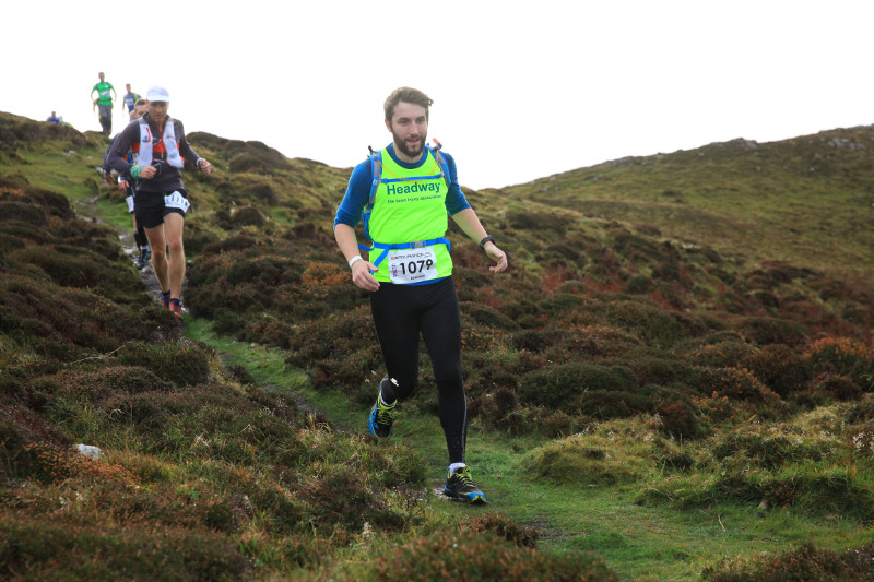 Lenny Martin running down a grassy hill in his Headway running vest