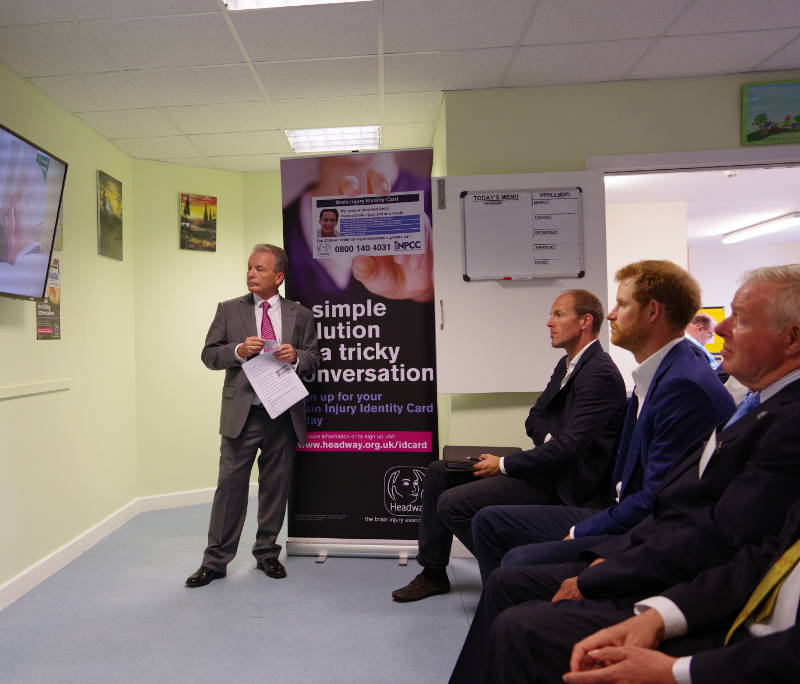 Prince Harry learns about the brain injury identity card in a presentation from Headway Chief Executive, Peter McCabe