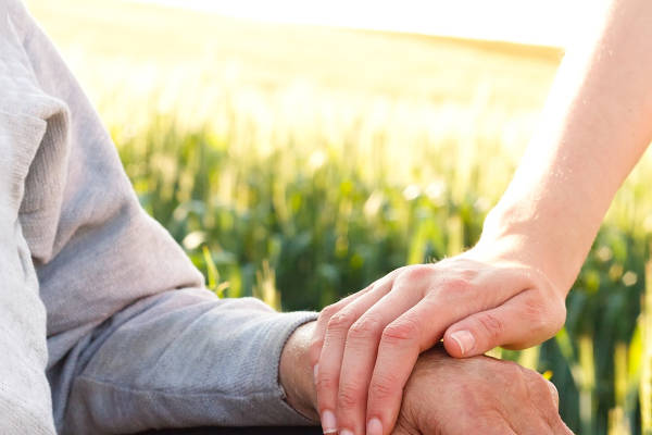 Two people holding hands for reassurance