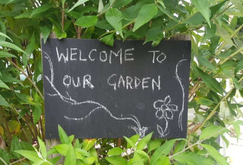 A sign saying welcome to our garden
