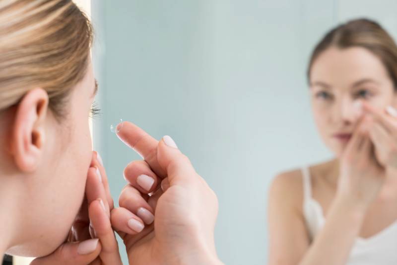 woman putting in contact lenses