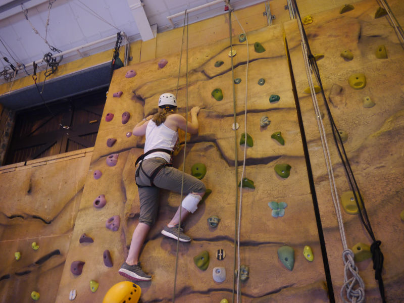 Adventurous Meg scales the climbing wall at Calvert Trust Lake District