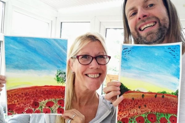 Mark and Jules hold up some of their artworks