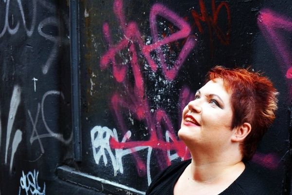 Nikki Webber MBE in front of a graffiti wall