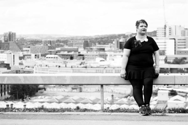 Nikki Webber MBE standing in front of a cityscape
