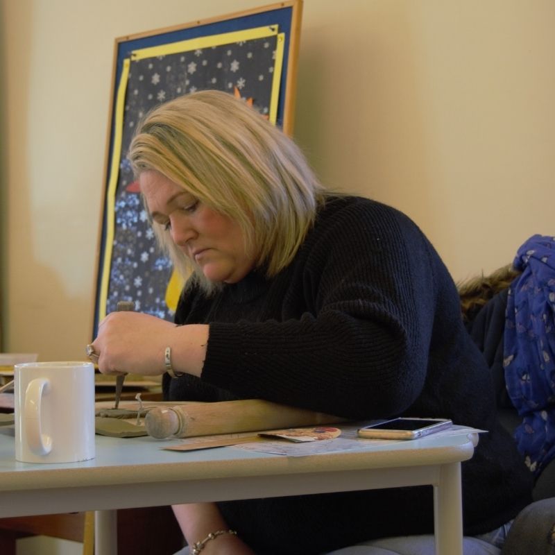 Lizzie concentrates on cutting out her pottery shapes